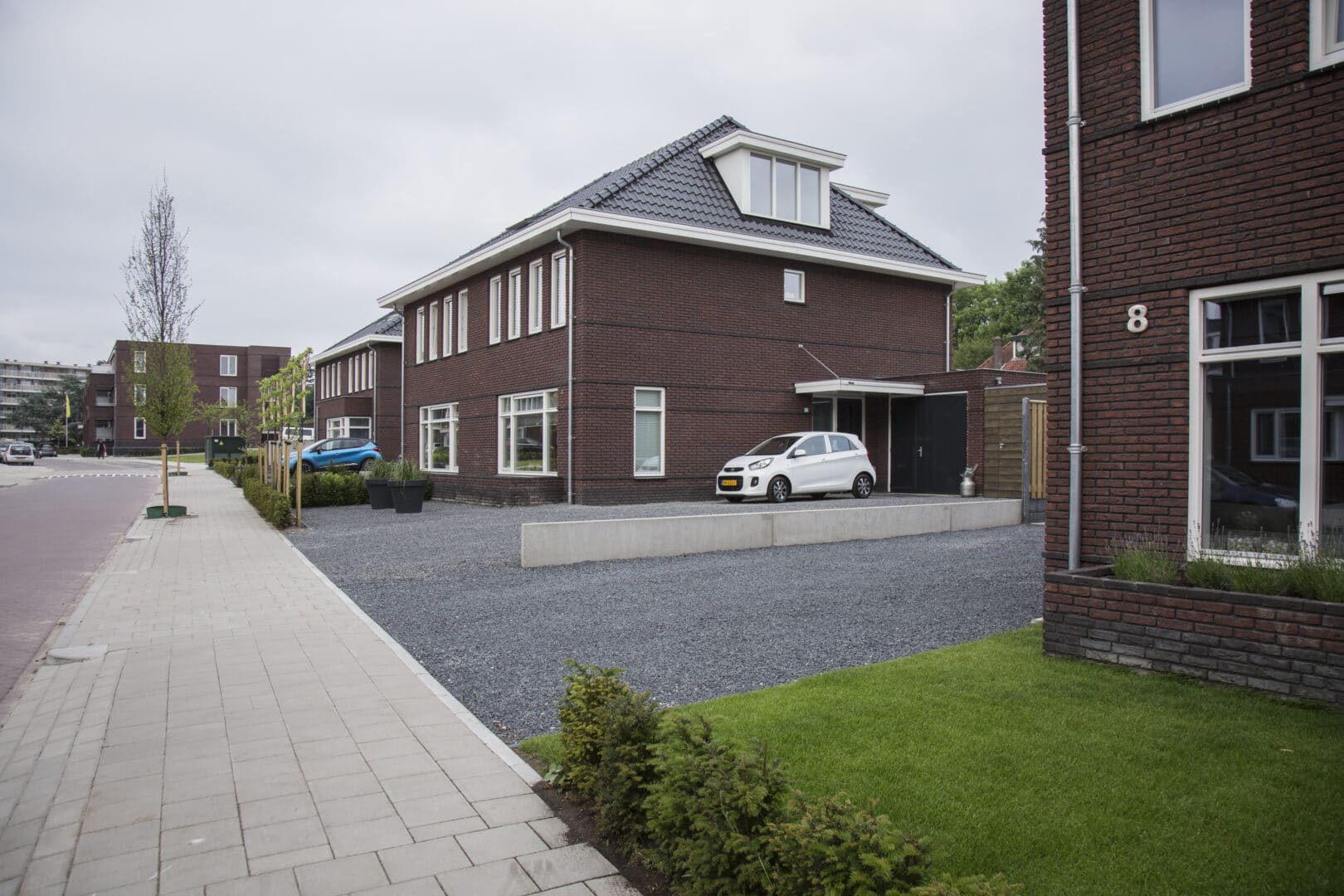 Bosch Beton - Niveauverschil opgevangen met keerwanden in oprit in woonwijk Soest